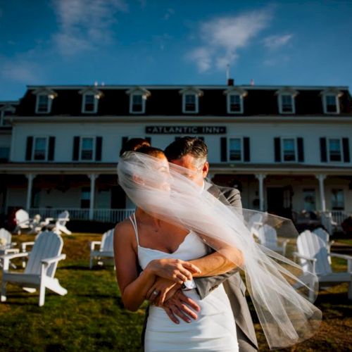 A couple embraces outdoors in front of a building with 