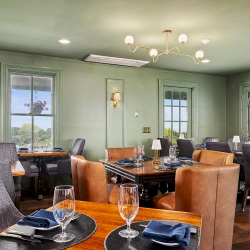 A classroom or conference room with desks arranged in rows, a whiteboard at front, and a few people seated as if for a meeting or lecture.